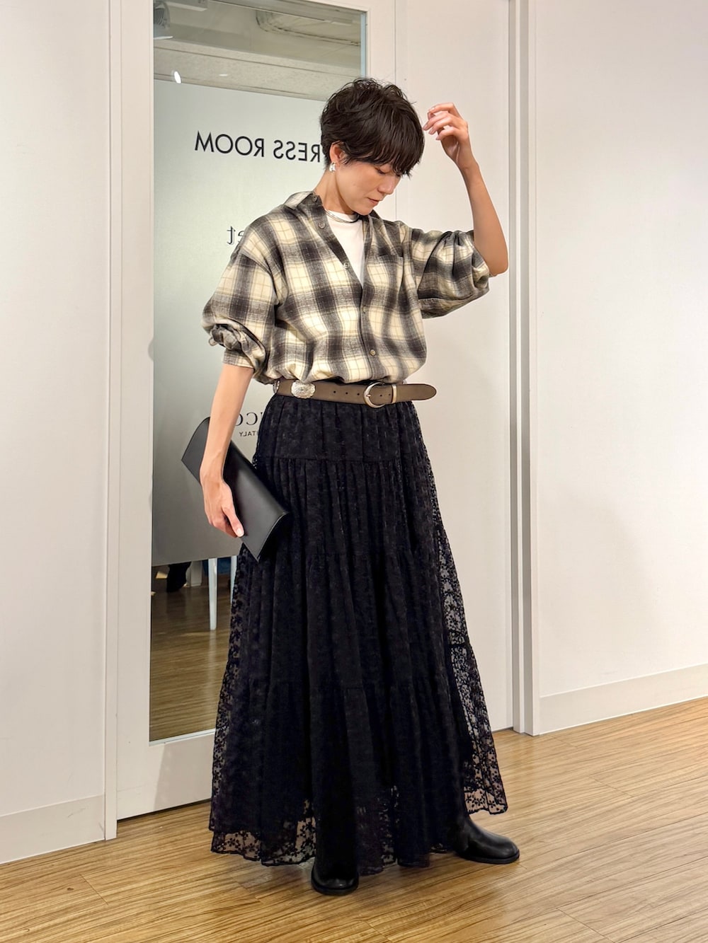 ブラック系のスカート、ベージュ系のシャツ/ブラウス、ホワイト系のTシャツ/カットソーを着用したレディースの秋コーディネートの2枚目の写真
