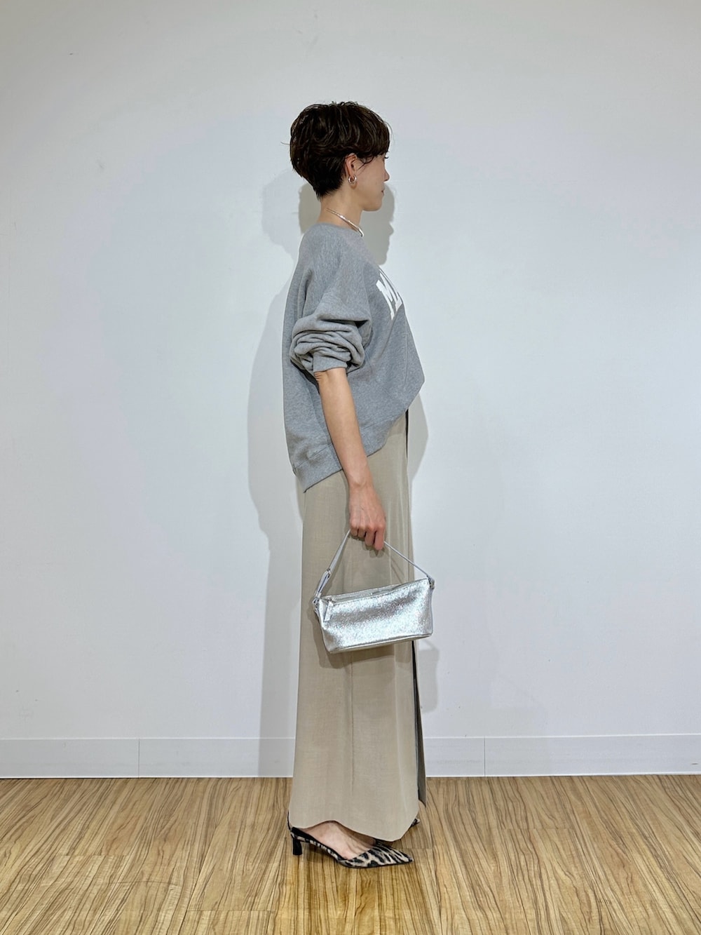 グレー系のスウェット、ベージュ系のスカート、イエロー系のパンプスを着用したレディースの冬コーディネートの3枚目の写真