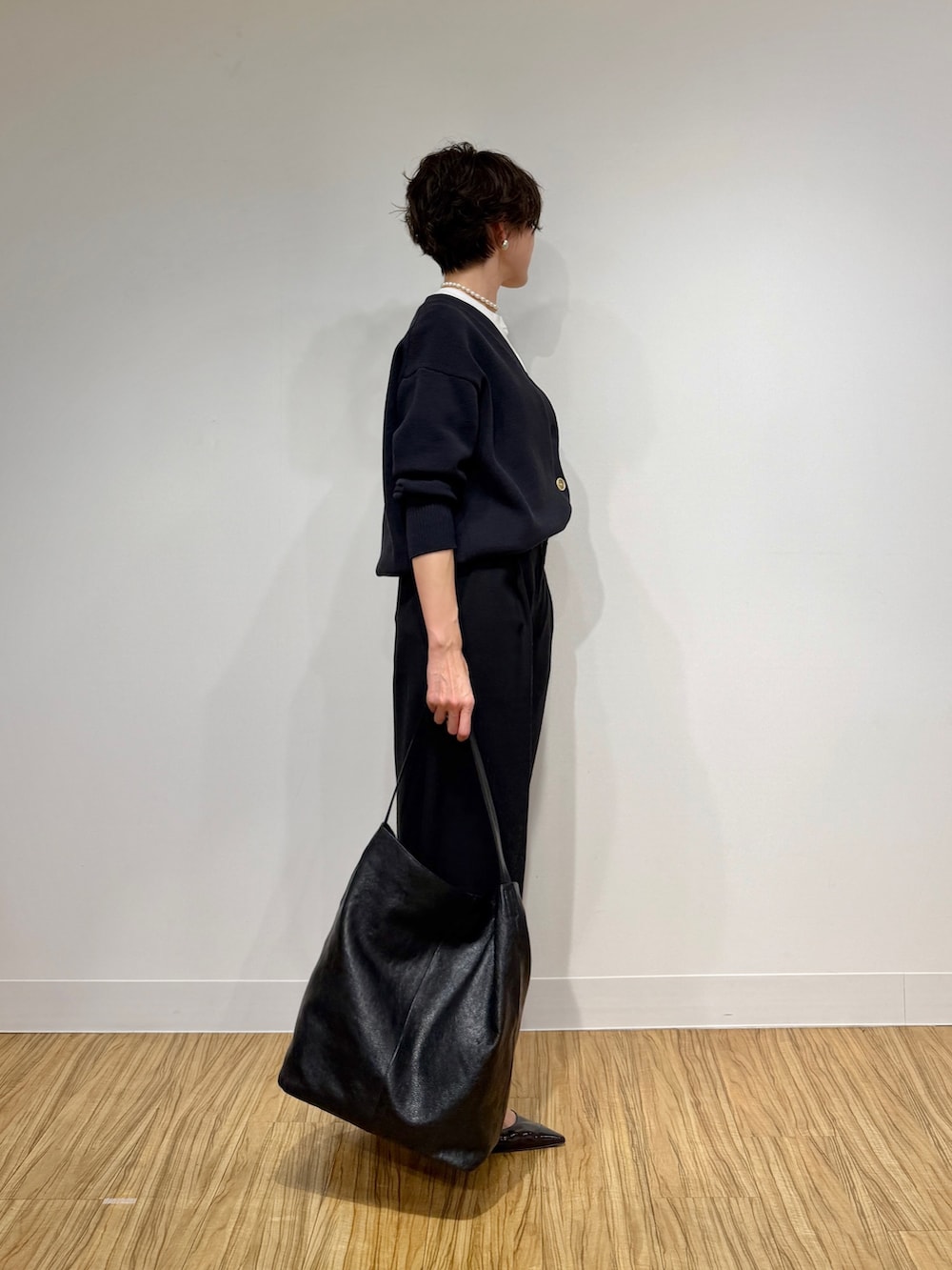 ブラック系のカーディガン/ボレロ、ホワイト系のTシャツ/カットソー、ブラック系のその他パンツを着用したレディースの冬コーディネートの3枚目の写真