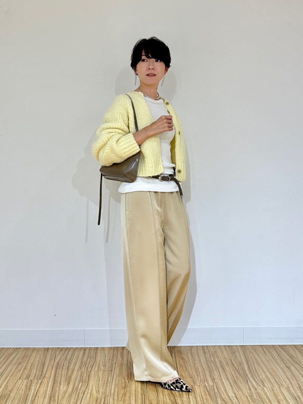イエロー系のカーディガン/ボレロ、ホワイト系のTシャツ/カットソー、ベージュ系のその他パンツを着用したレディースの秋コーディネートの2枚目の写真