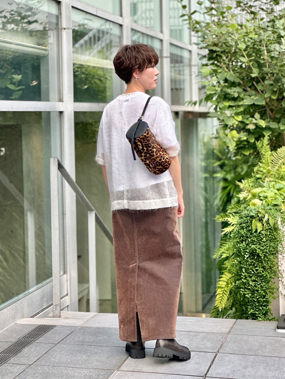 ブラック系のブーツ、ホワイト系のTシャツ/カットソー、ブラウン系のデニムスカートを着用したレディースの夏コーディネートの4枚目の写真