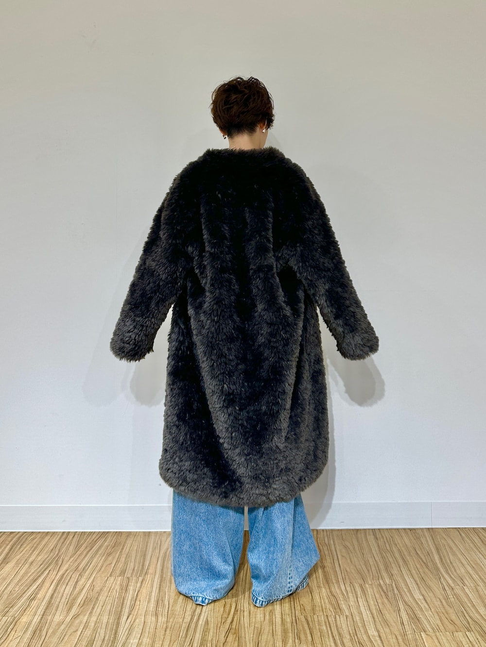 ブラック系のパンプス、ブルー系のデニムパンツ、グレー系のその他アウターを着用したレディースの秋コーディネートの4枚目の写真