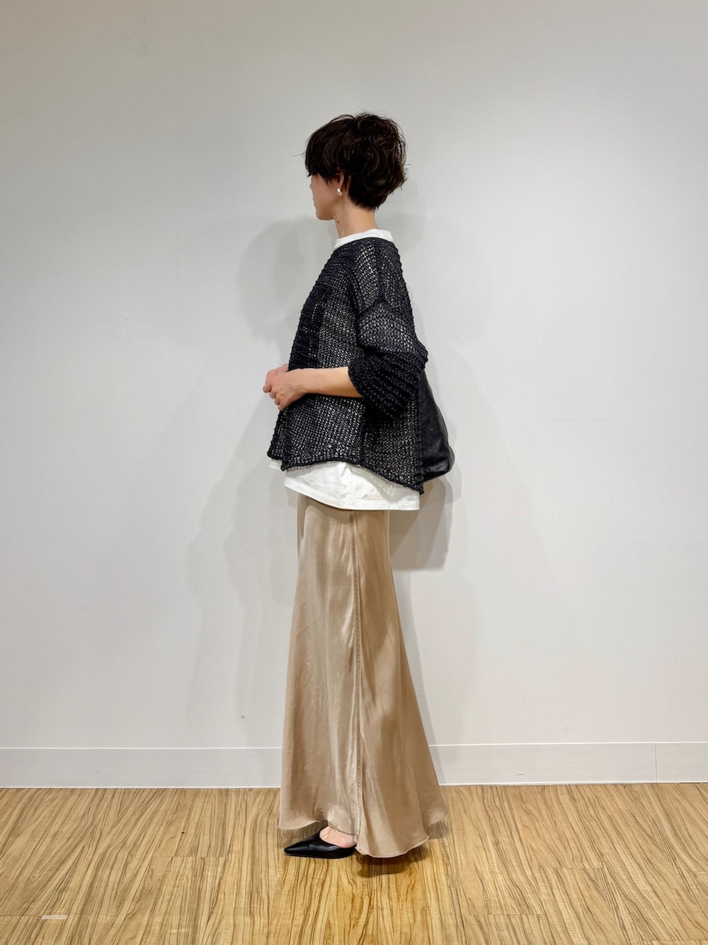 ホワイト系のTシャツ/カットソー、グレー系のニット/セーター、ベージュ系のスカートを着用したレディースの冬コーディネートの5枚目の写真