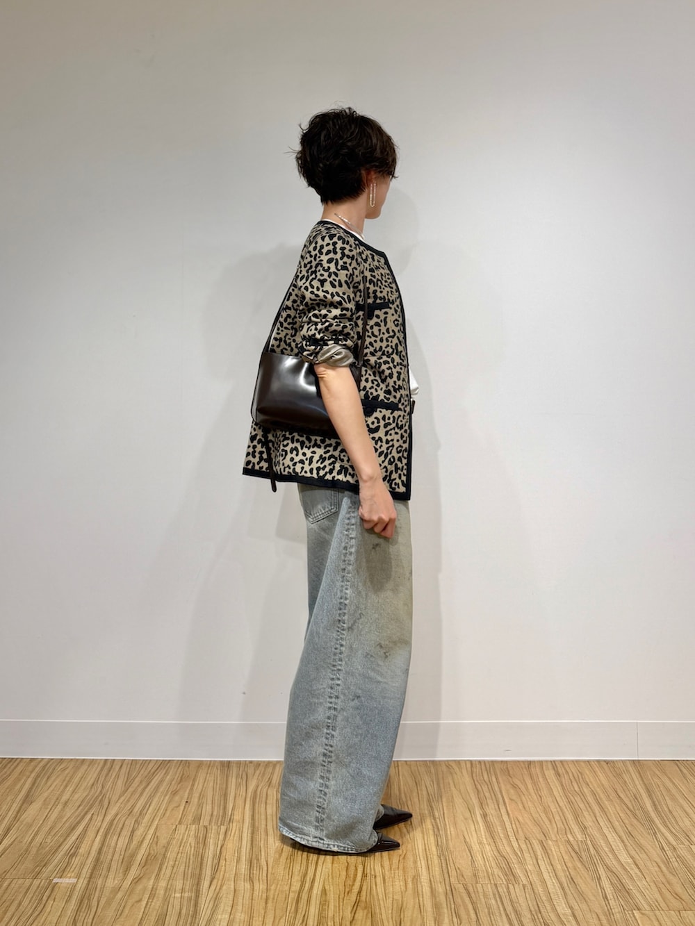 ブラック系のノーカラージャケット、ホワイト系のTシャツ/カットソー、ブルー系のデニムパンツを着用したレディースの冬コーディネートの3枚目の写真