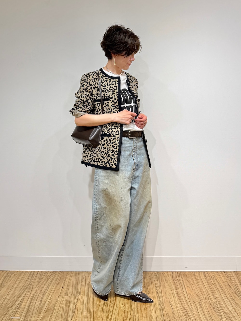 ブラック系のノーカラージャケット、ホワイト系のTシャツ/カットソー、ブルー系のデニムパンツを着用したレディースの冬コーディネートの2枚目の写真