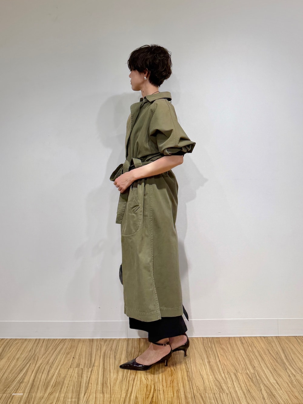 グリーン系のその他アウター、ブラック系のワンピース、ブラウン系のパンプスを着用したレディースの冬コーディネートの5枚目の写真