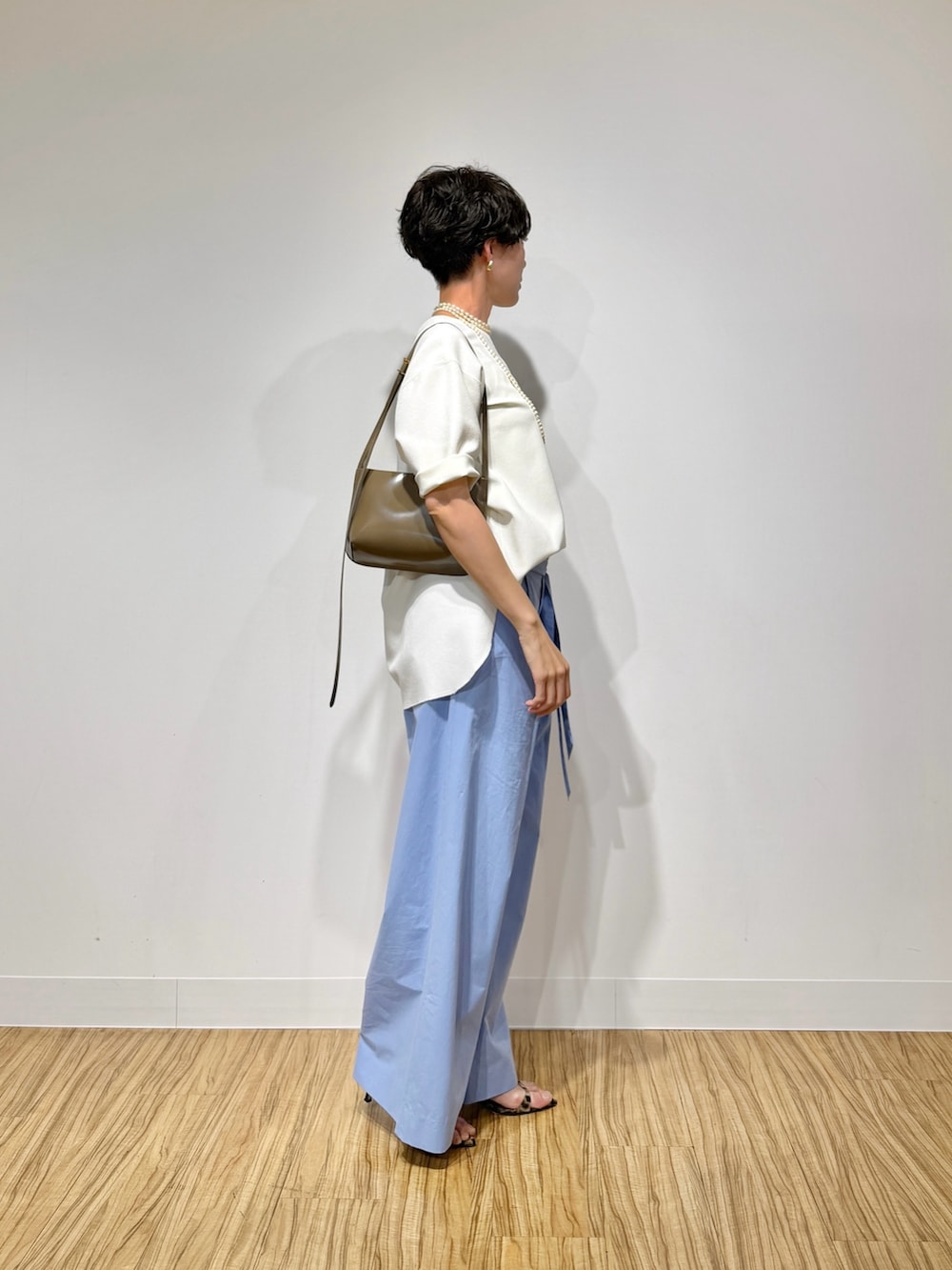 ホワイト系のシャツ/ブラウス、ブルー系のその他パンツ、ブラウン系のショルダーバッグを着用したレディースの春コーディネートの3枚目の写真