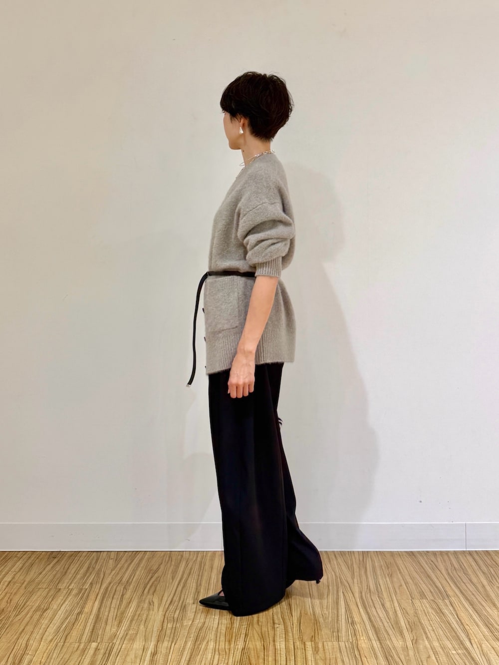 ブラウン系のカーディガン/ボレロ、ブラック系のその他パンツ、ホワイト系のクラッチバッグを着用したレディースの秋コーディネートの5枚目の写真