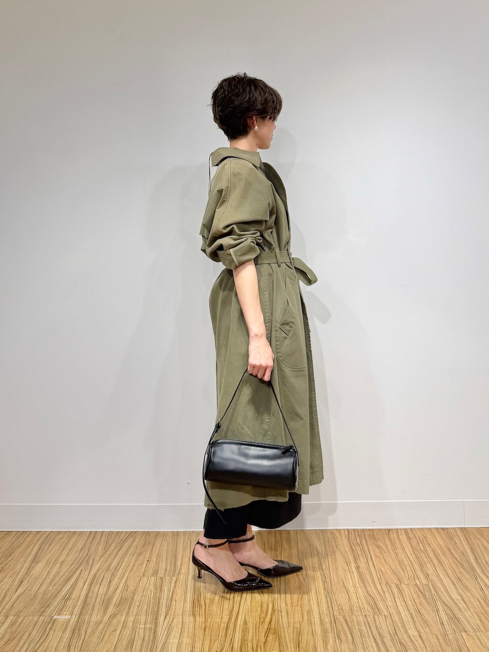 グリーン系のその他アウター、ブラック系のワンピース、ブラウン系のパンプスを着用したレディースの冬コーディネートの3枚目の写真