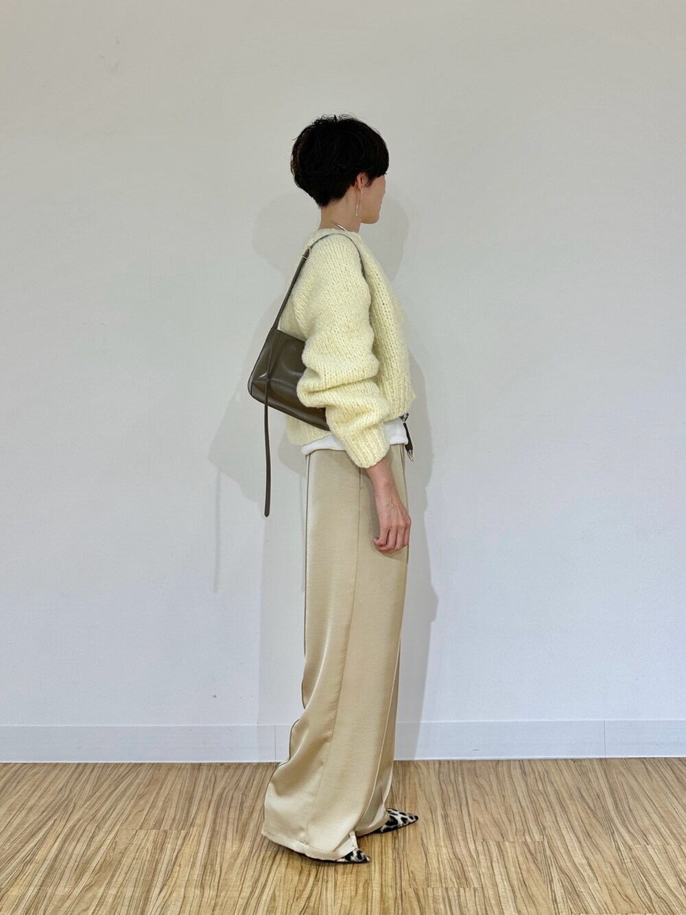 イエロー系のカーディガン/ボレロ、ホワイト系のTシャツ/カットソー、ベージュ系のその他パンツを着用したレディースの秋コーディネートの3枚目の写真