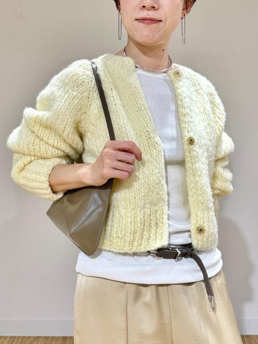 イエロー系のカーディガン/ボレロ、ホワイト系のTシャツ/カットソー、ベージュ系のその他パンツを着用したレディースの秋コーディネートの6枚目の写真