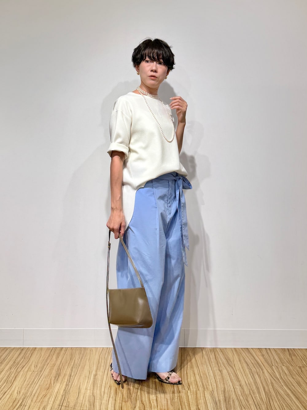 ホワイト系のシャツ/ブラウス、ブルー系のその他パンツ、ブラウン系のショルダーバッグを着用したレディースの春コーディネートの6枚目の写真