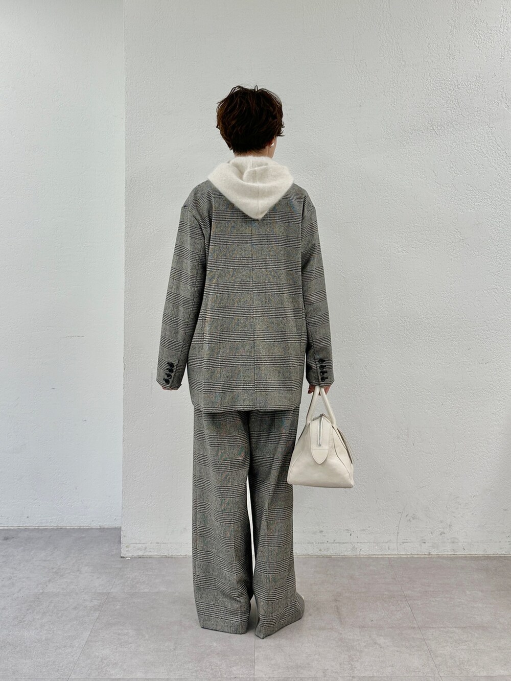 ベージュ系のニット/セーター、ホワイト系のトートバッグ、ベージュ系のパンプスを着用したレディースの秋コーディネートの4枚目の写真