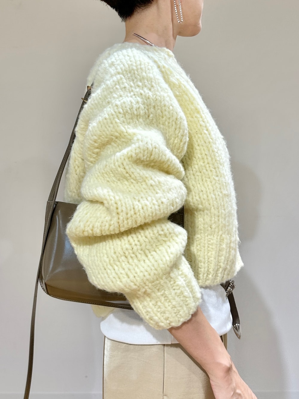 イエロー系のカーディガン/ボレロ、ホワイト系のTシャツ/カットソー、ベージュ系のその他パンツを着用したレディースの秋コーディネートの7枚目の写真