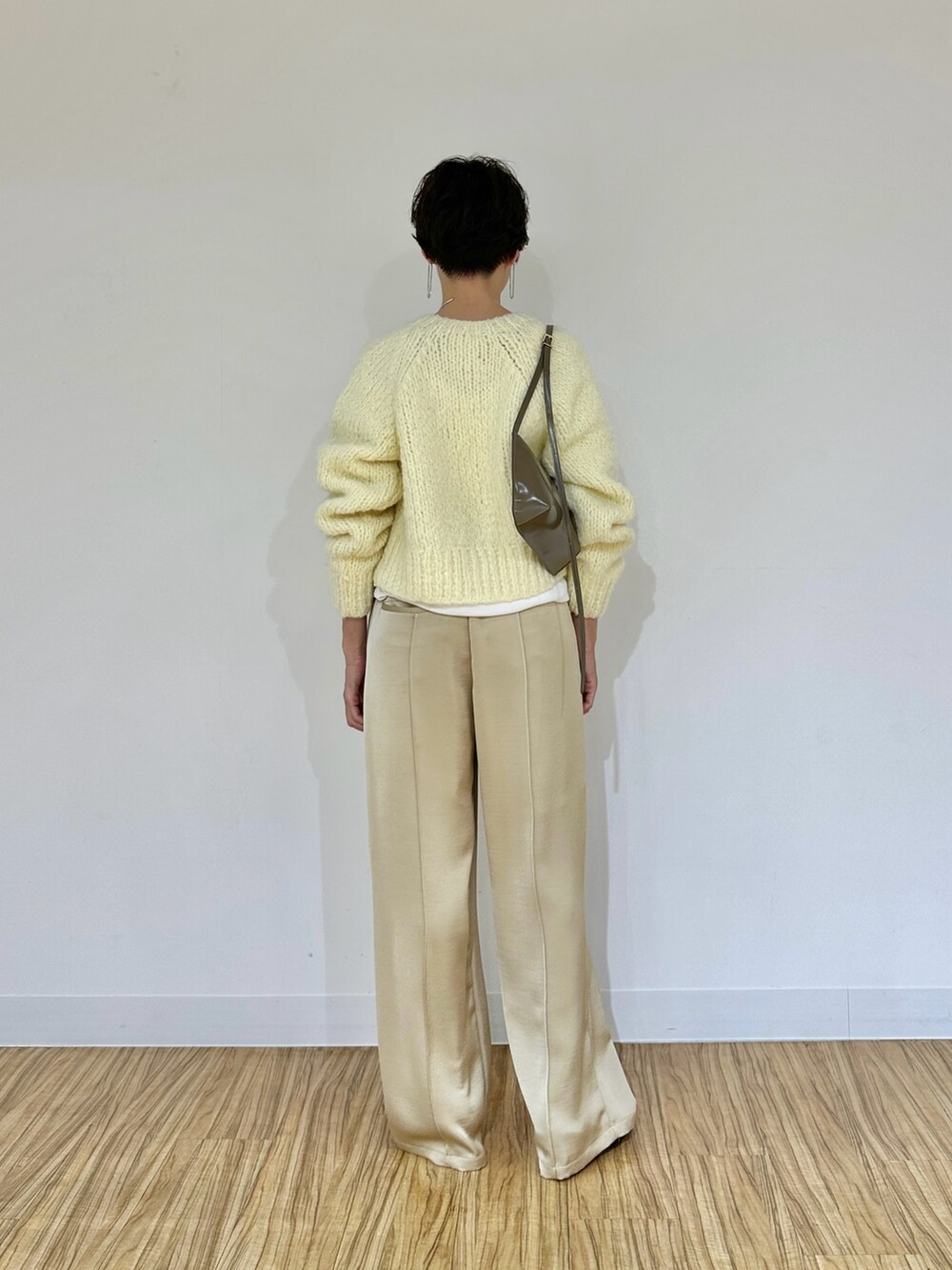 イエロー系のカーディガン/ボレロ、ホワイト系のTシャツ/カットソー、ベージュ系のその他パンツを着用したレディースの秋コーディネートの4枚目の写真