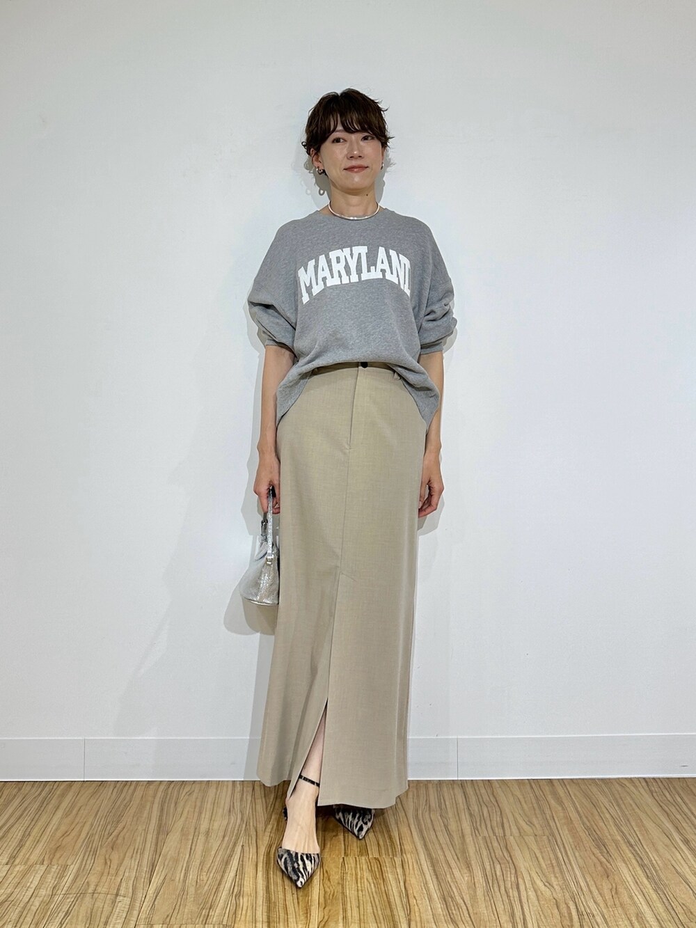 グレー系のスウェット、ベージュ系のスカート、イエロー系のパンプスを着用したレディースの冬コーディネートの2枚目の写真