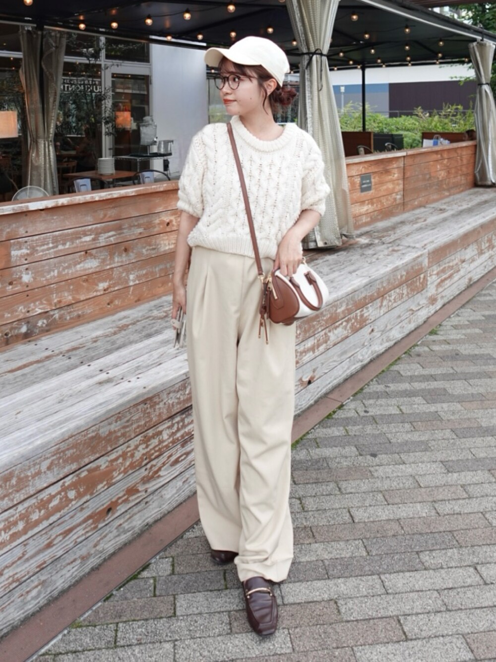 ベージュ系のサロペット/オーバーオール、ホワイト系のニット/セーター、グレー系のトートバッグを着用したレディースの夏コーディネートの2枚目の写真