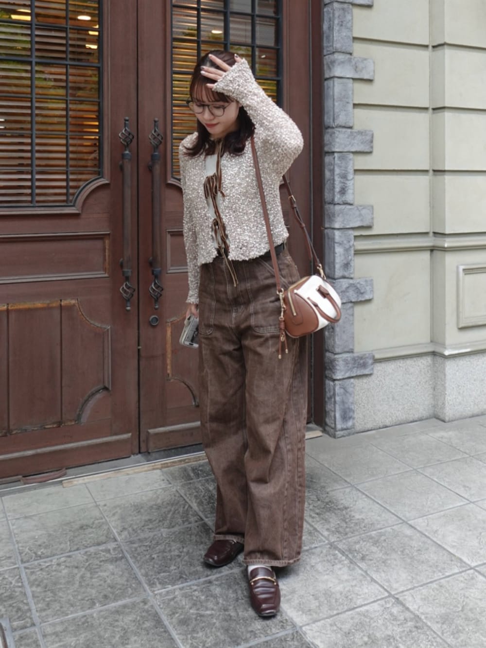 ベージュ系のニット/セーター、ブラウン系のデニムパンツ、ブラウン系のローファーを着用したレディースの秋コーディネートの3枚目の写真