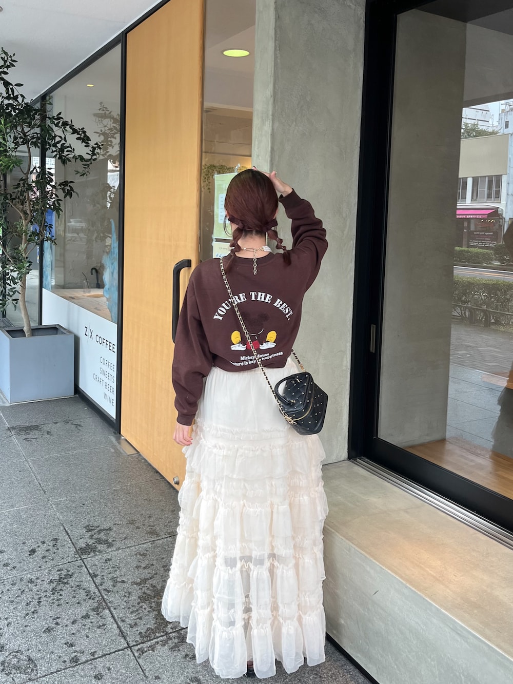 ブラウン系のスウェット、ブラック系のショルダーバッグ、ホワイト系のスカートを着用したレディースの秋コーディネートの4枚目の写真