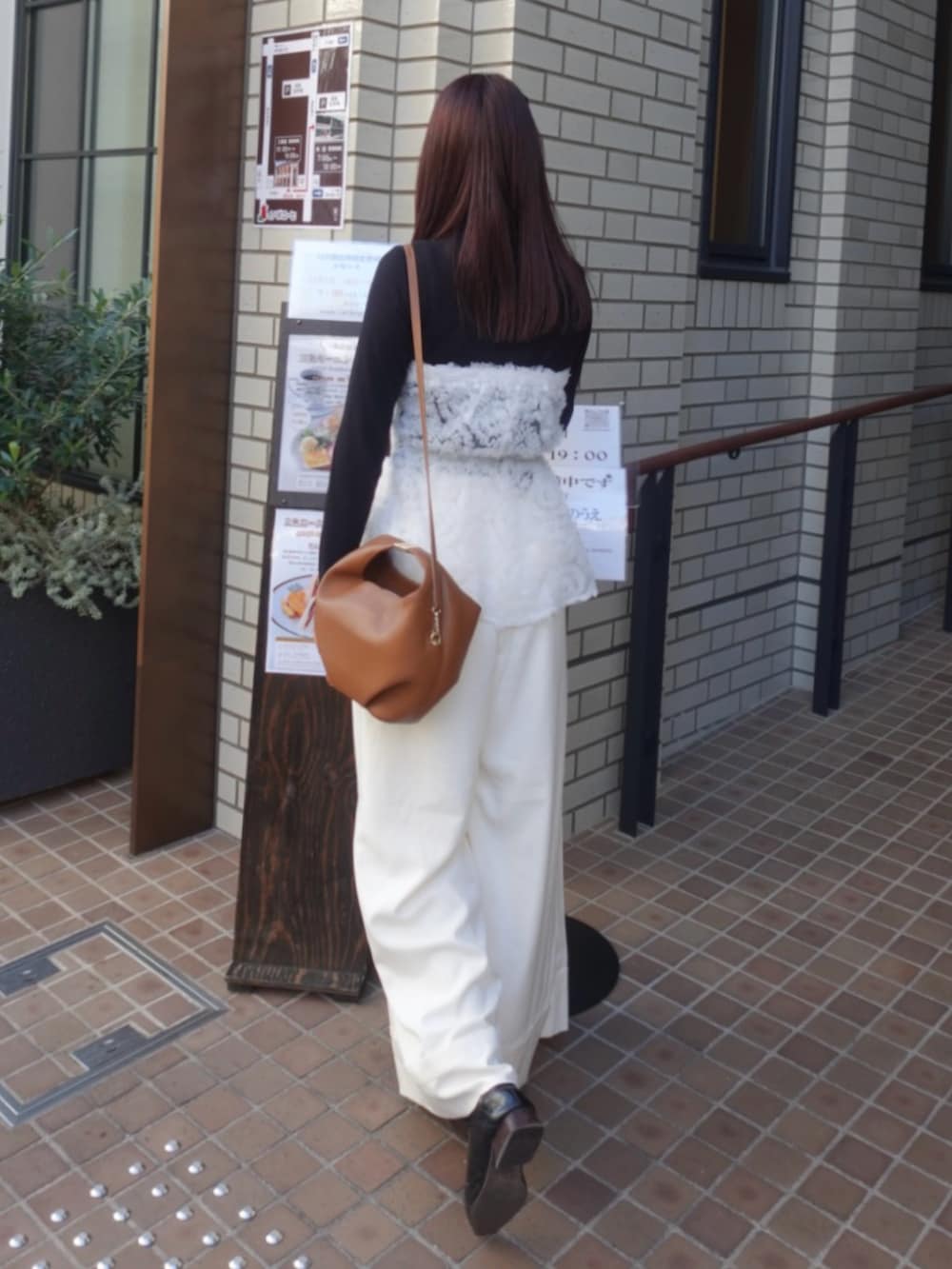 ホワイト系のシャツ/ブラウス、ブラック系のニット/セーター、ホワイト系のスラックスを着用したレディースの冬コーディネートの2枚目の写真