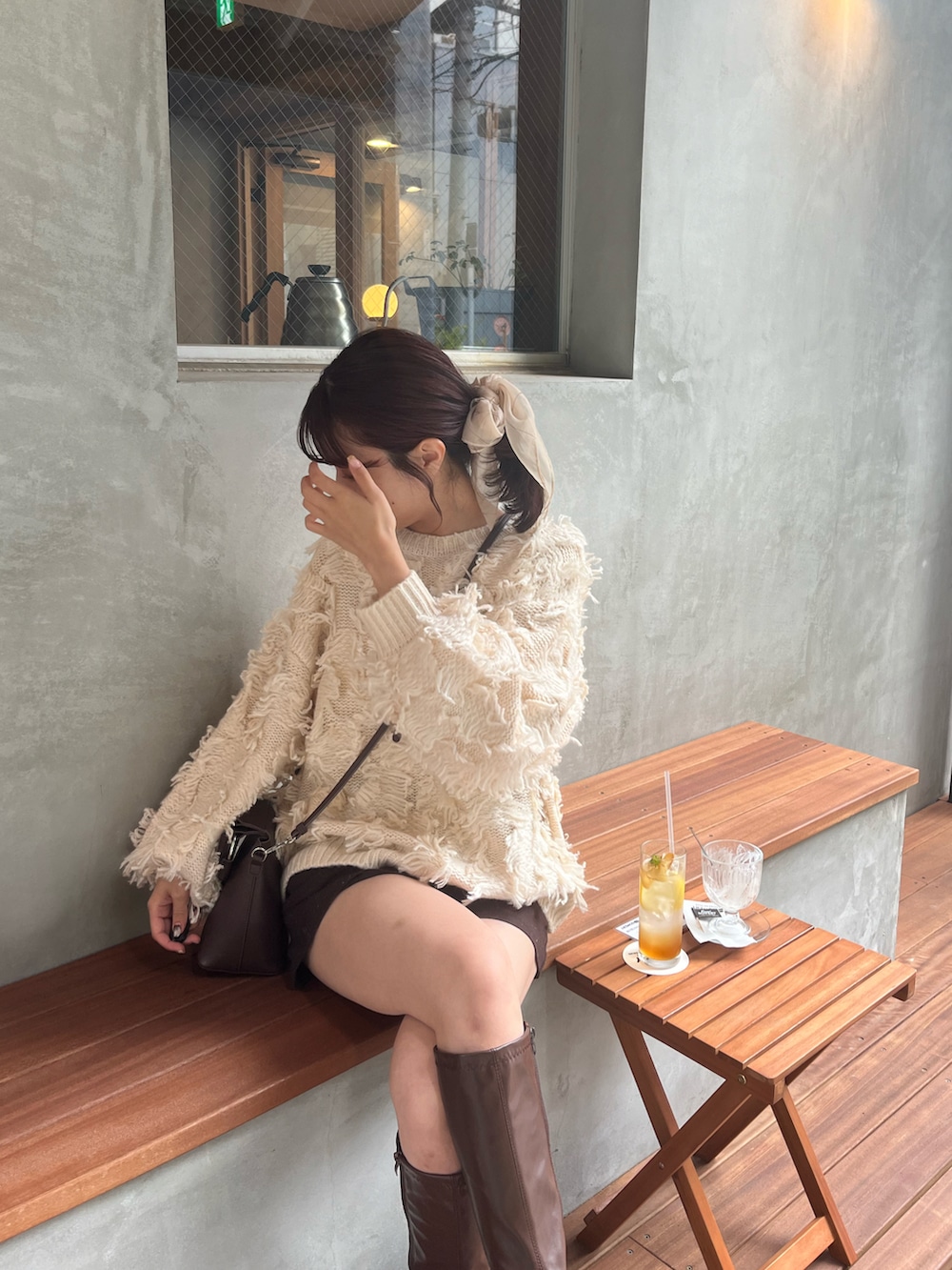 ホワイト系のニット/セーター、ブラウン系のその他パンツ、ブラウン系のブーツを着用したレディースの秋コーディネートの3枚目の写真