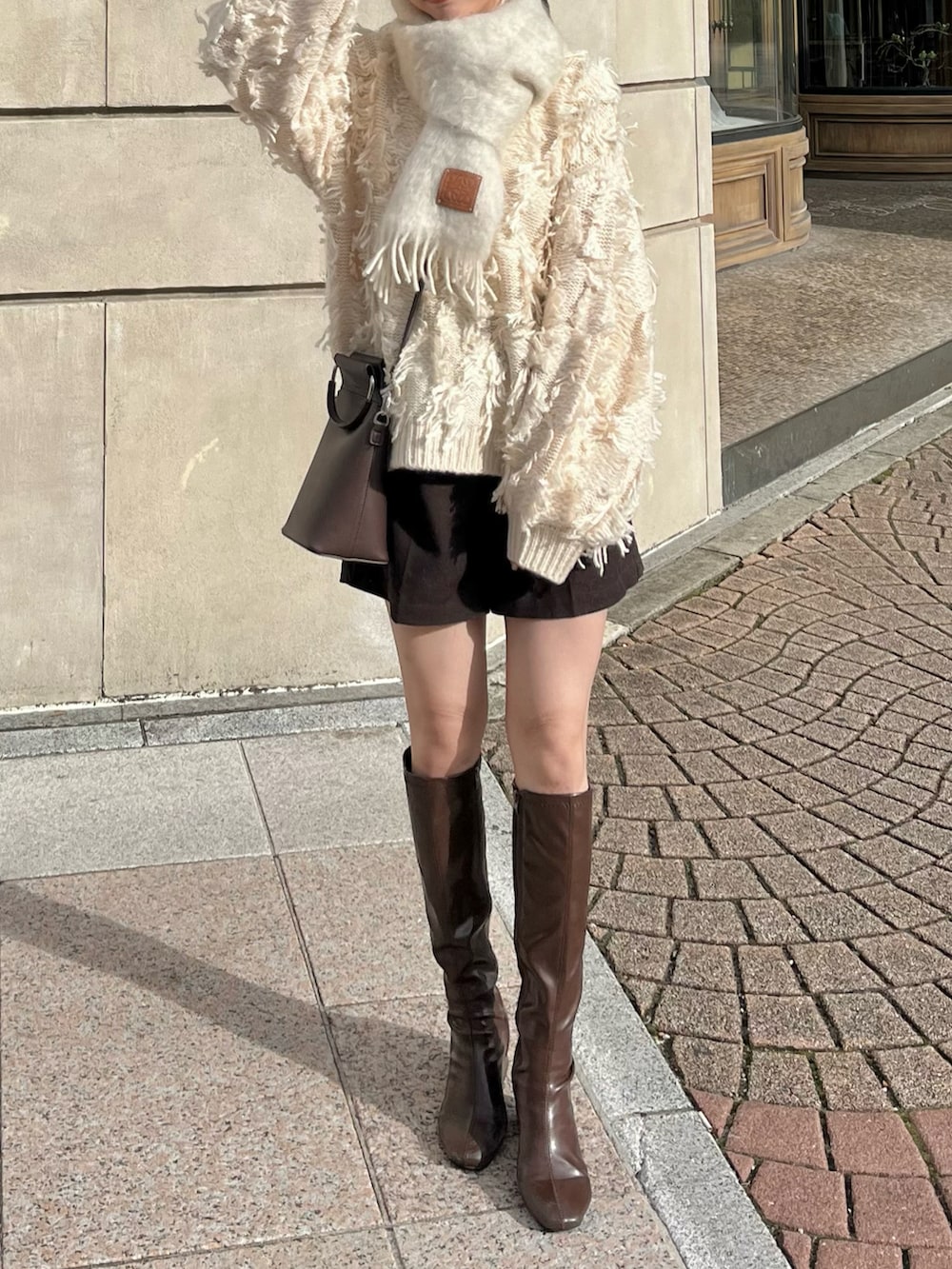 ホワイト系のニット/セーター、ブラウン系のその他パンツ、ブラウン系のブーツを着用したレディースの秋コーディネートの2枚目の写真