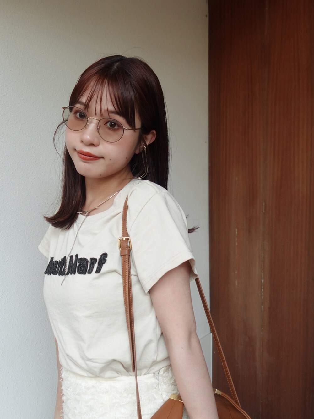 ホワイト系のスカート、ベージュ系のTシャツ/カットソー、ブラウン系のローファーを着用したレディースの夏コーディネートの3枚目の写真