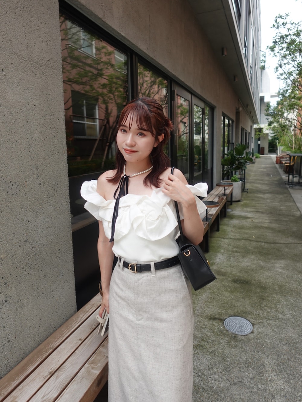 ベージュ系のスカート、ブラック系のパンプス、ホワイト系のニット/セーターを着用したレディースの夏コーディネートの4枚目の写真