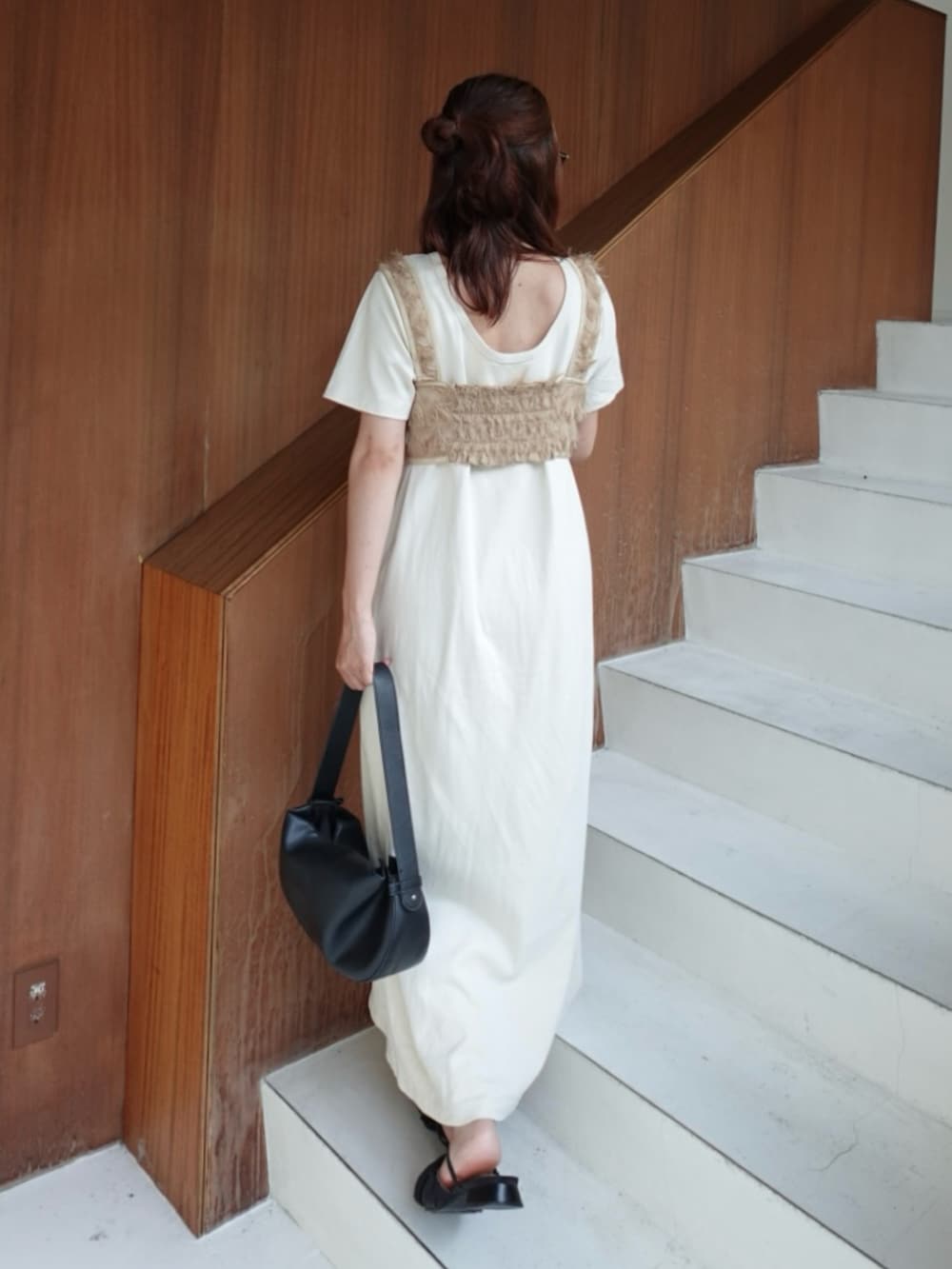 ホワイト系のワンピース、ブラック系のサンダル、ブラック系のトートバッグを着用したレディースの夏コーディネートの3枚目の写真