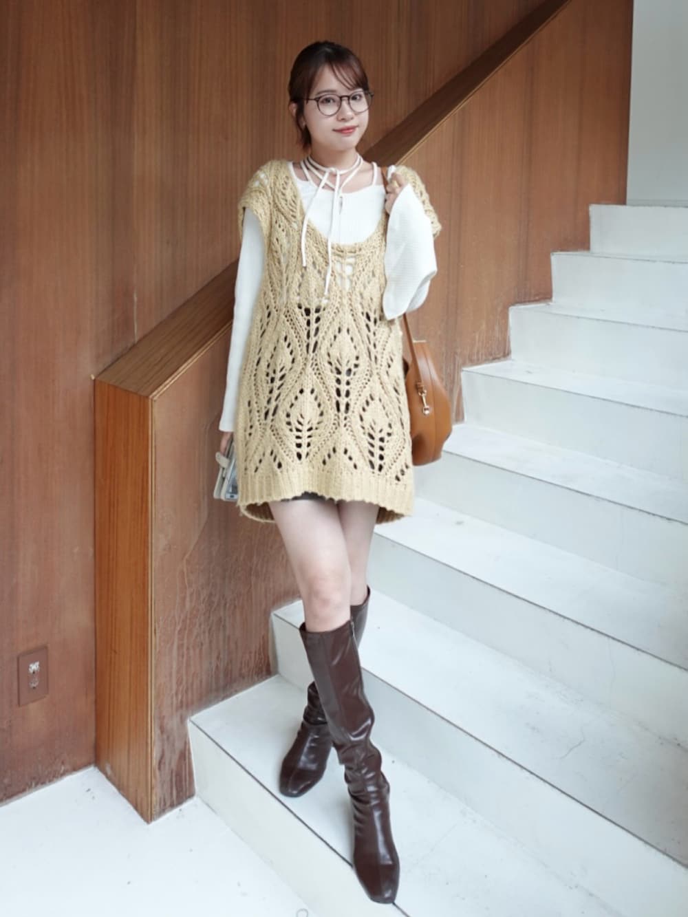 ベージュ系のベスト、ブラウン系のパンツ、ブラウン系のブーツを着用したレディースの秋コーディネートの2枚目の写真