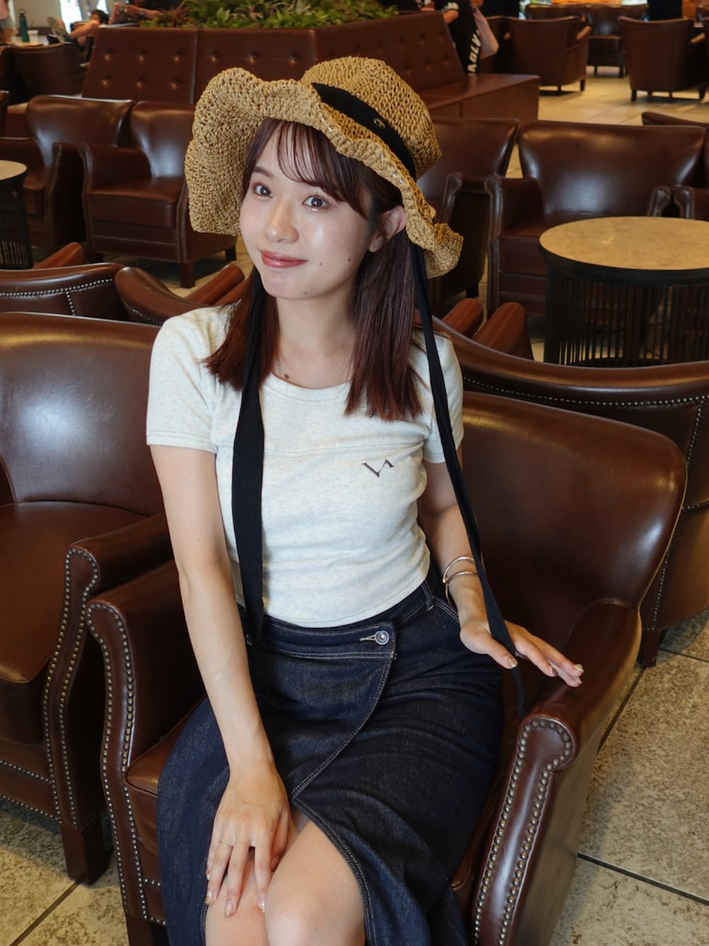 ブルー系のデニムスカート、ブラック系のパンプス、ブラック系のトートバッグを着用したレディースの夏コーディネートの4枚目の写真