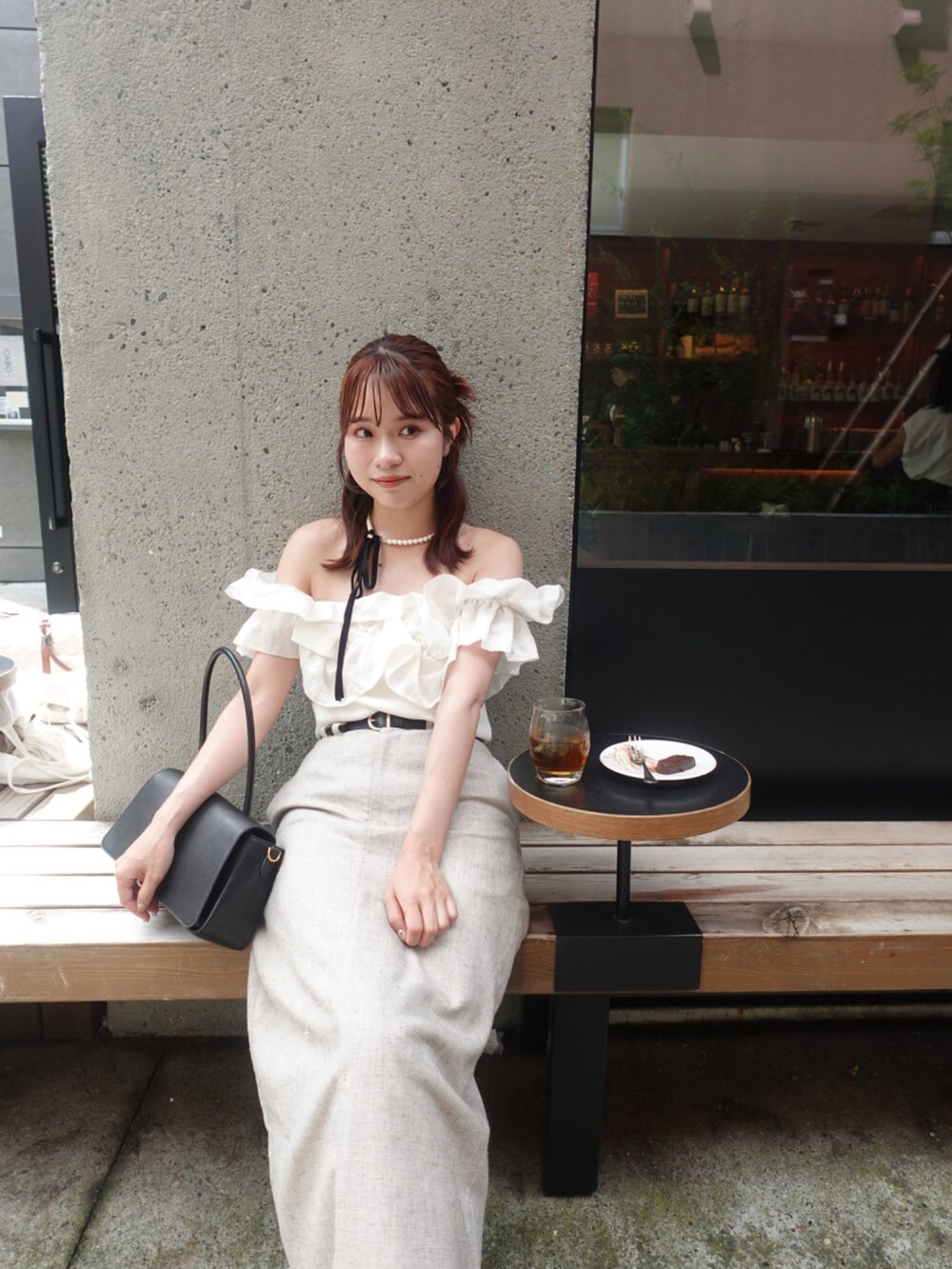 ベージュ系のスカート、ブラック系のパンプス、ホワイト系のニット/セーターを着用したレディースの夏コーディネートの3枚目の写真