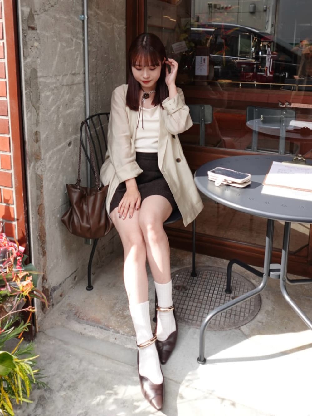 ホワイト系のチューブトップ、ブラウン系のスカート、ベージュ系のシャツ/ブラウスを着用したレディースの秋コーディネートの5枚目の写真