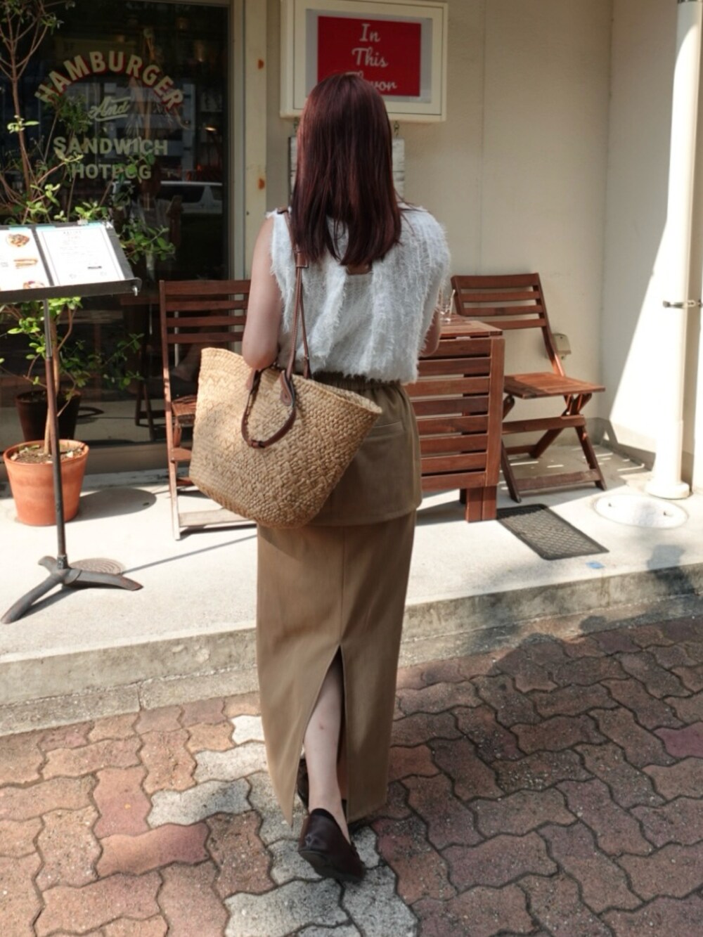 ベージュ系のスカート、ホワイト系のシャツ/ブラウス、ブラウン系のトートバッグを着用したレディースの夏コーディネートの2枚目の写真