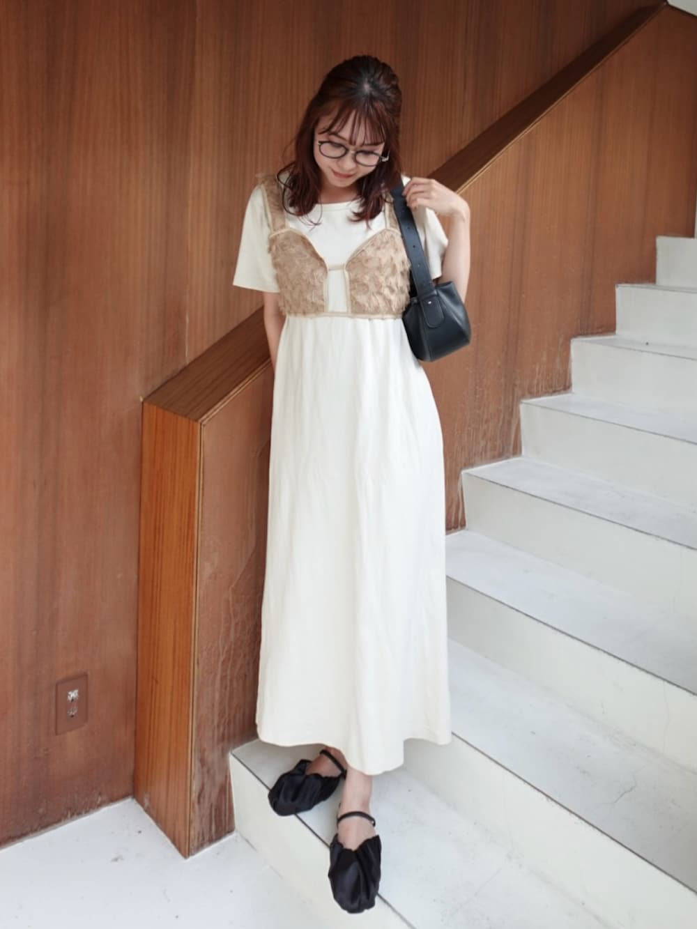 ホワイト系のワンピース、ブラック系のサンダル、ブラック系のトートバッグを着用したレディースの夏コーディネートの2枚目の写真