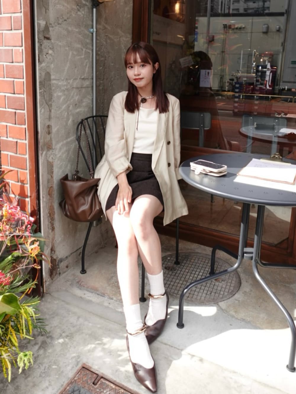 ホワイト系のチューブトップ、ブラウン系のスカート、ベージュ系のシャツ/ブラウスを着用したレディースの秋コーディネートの4枚目の写真