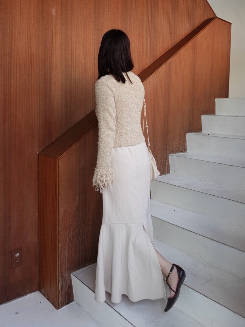 ベージュ系のカーディガン/ボレロ、ブラウン系のパンプス、ホワイト系のスカートを着用したレディースの春コーディネートの3枚目の写真