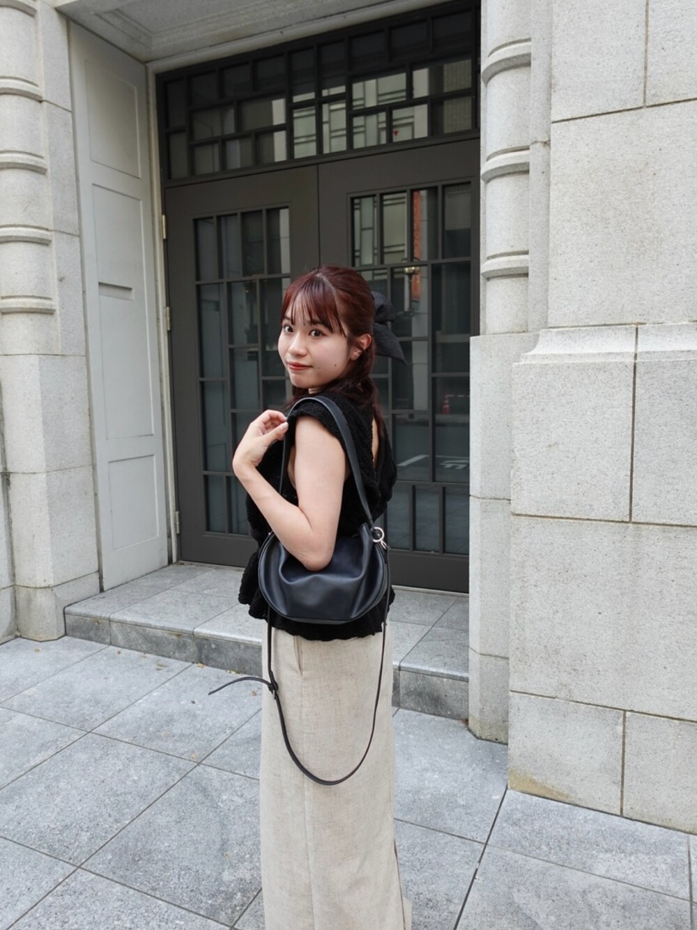 ブラック系のニット/セーター、ベージュ系のスカート、ブラック系のトートバッグを着用したレディースの秋コーディネートの4枚目の写真