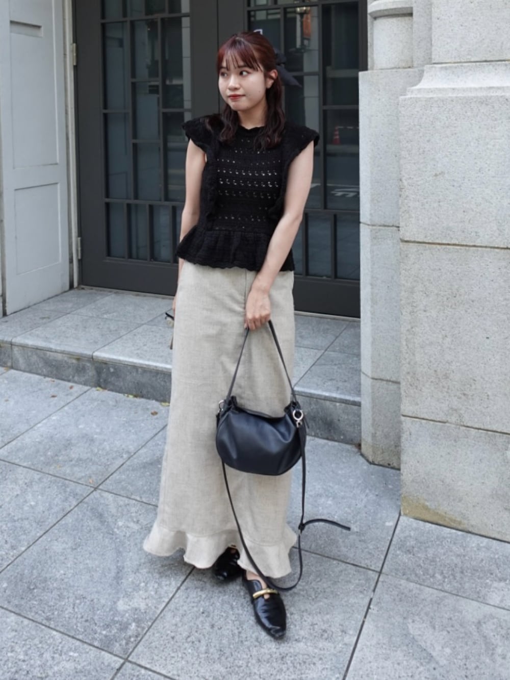 ブラック系のニット/セーター、ベージュ系のスカート、ブラック系のトートバッグを着用したレディースの秋コーディネートの2枚目の写真