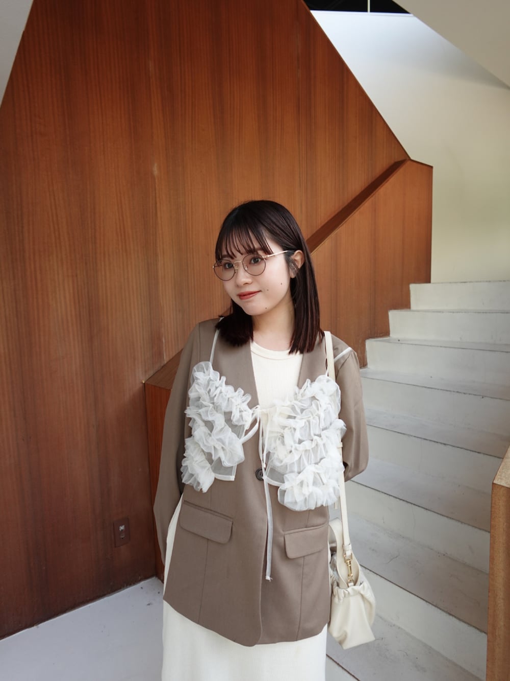 ブラウン系のノーカラージャケット、ホワイト系のキャミソール、ホワイト系のワンピースを着用したレディースの春コーディネートの4枚目の写真