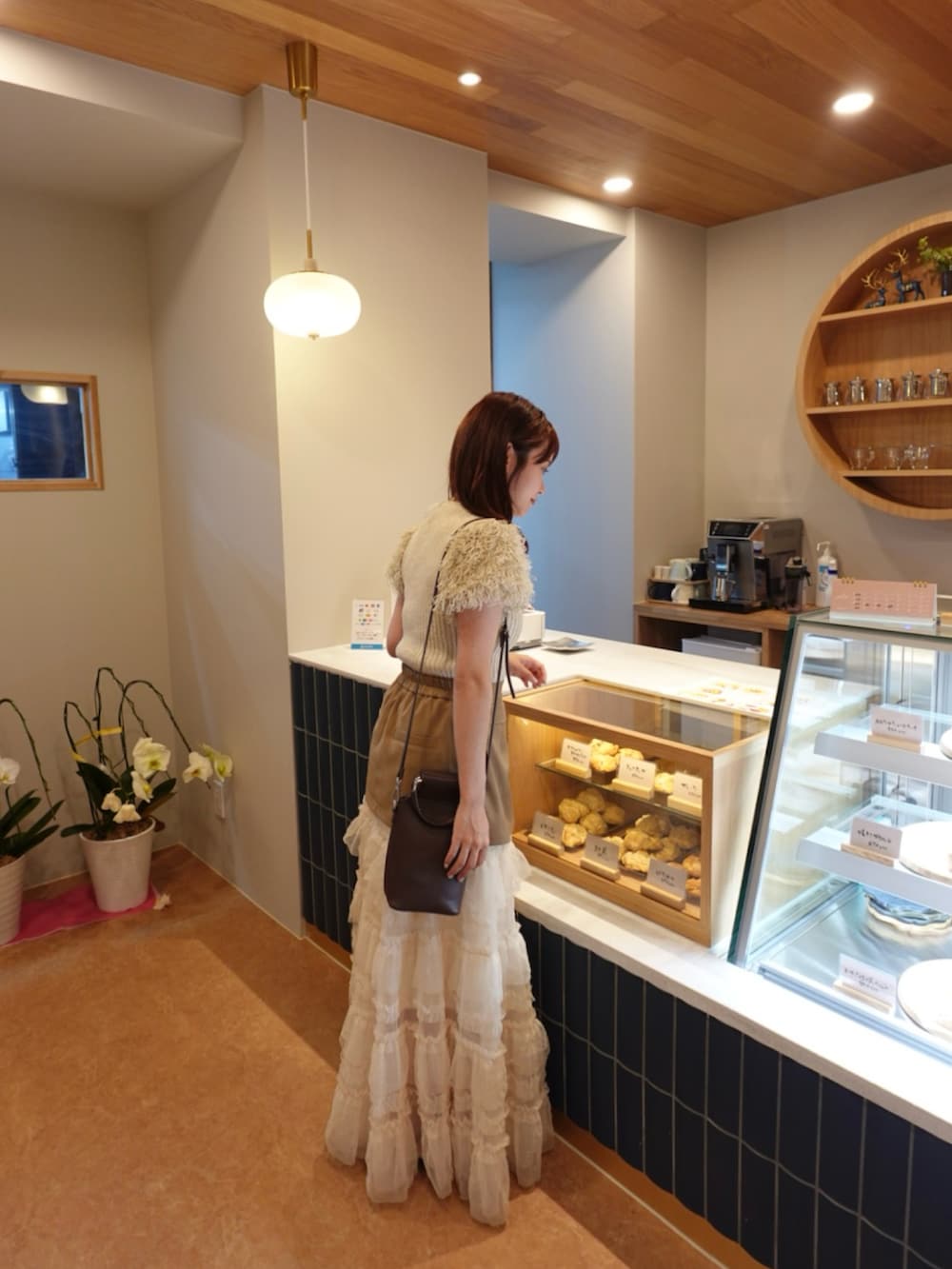 ホワイト系のスカート、ベージュ系のスカート、ホワイト系のニット/セーターを着用したレディースの夏コーディネートの2枚目の写真