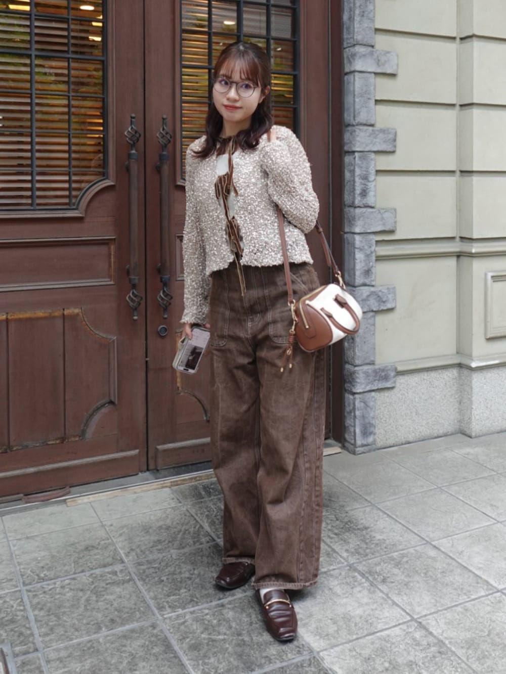 ベージュ系のニット/セーター、ブラウン系のデニムパンツ、ブラウン系のローファーを着用したレディースの秋コーディネートの2枚目の写真