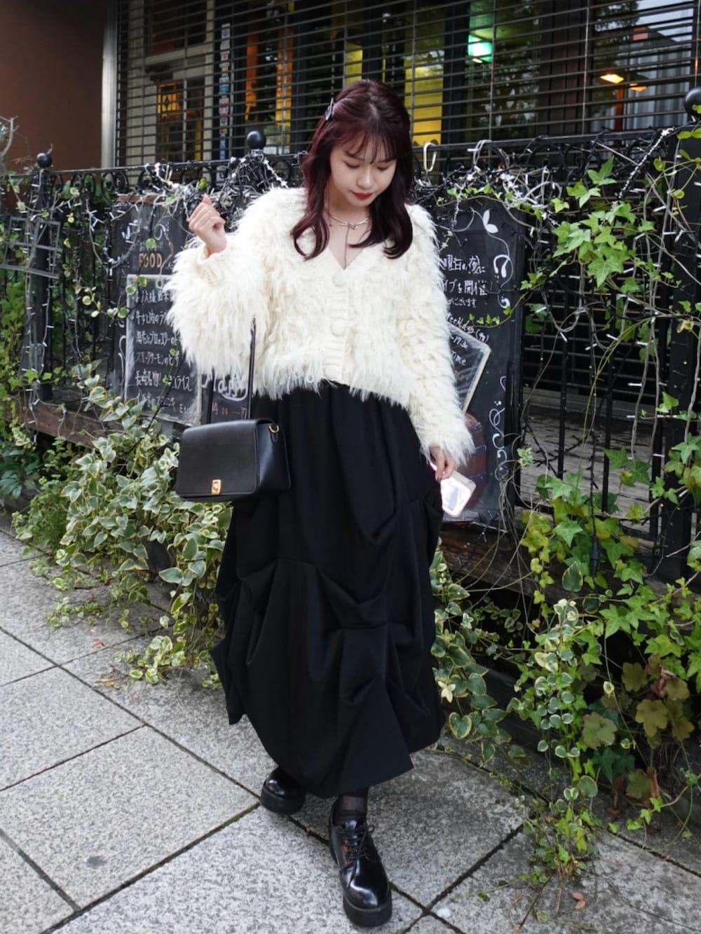ホワイト系のカーディガン/ボレロ、ブラック系のローファー、ブラック系のスカートを着用したレディースの秋コーディネートの2枚目の写真