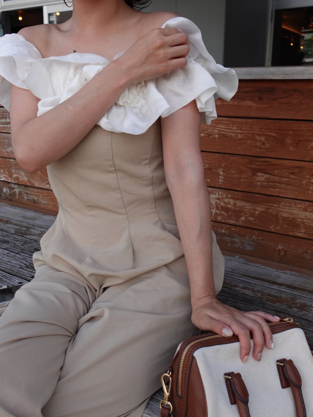 グレー系のトートバッグ、ブラウン系のパンプス、ホワイト系のニット/セーターを着用したレディースの夏コーディネートの5枚目の写真