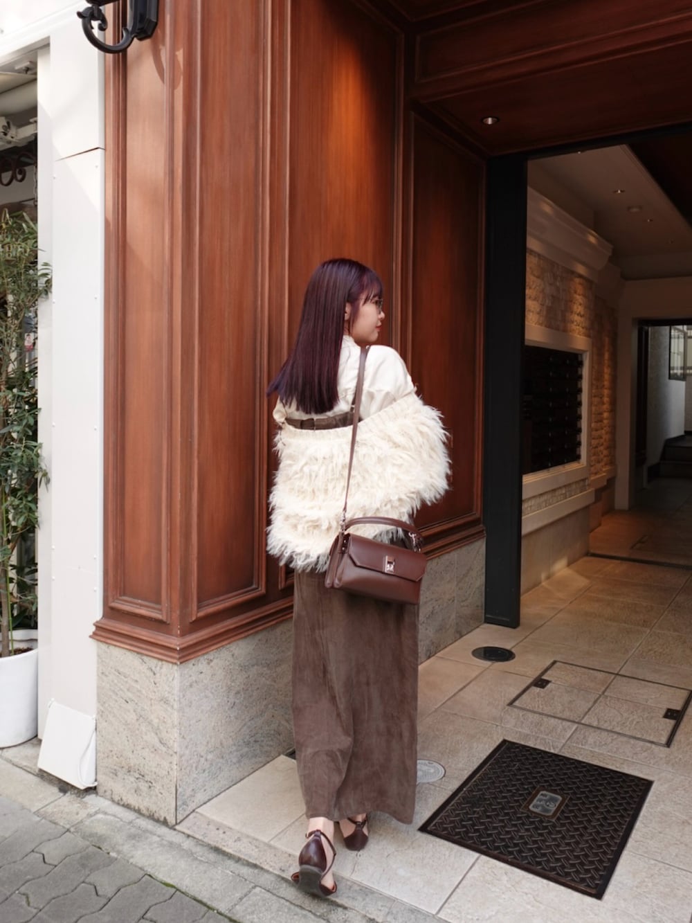 ブラウン系のショルダーバッグ、ブラウン系のパンプス、ブラウン系のワンピースを着用したレディースの秋コーディネートの3枚目の写真