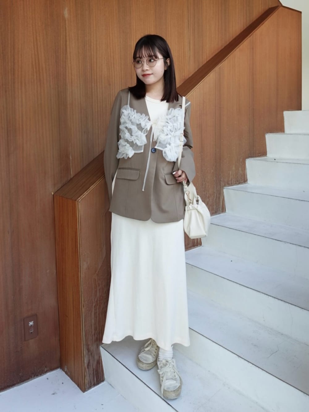 ブラウン系のノーカラージャケット、ホワイト系のキャミソール、ホワイト系のワンピースを着用したレディースの春コーディネートの2枚目の写真
