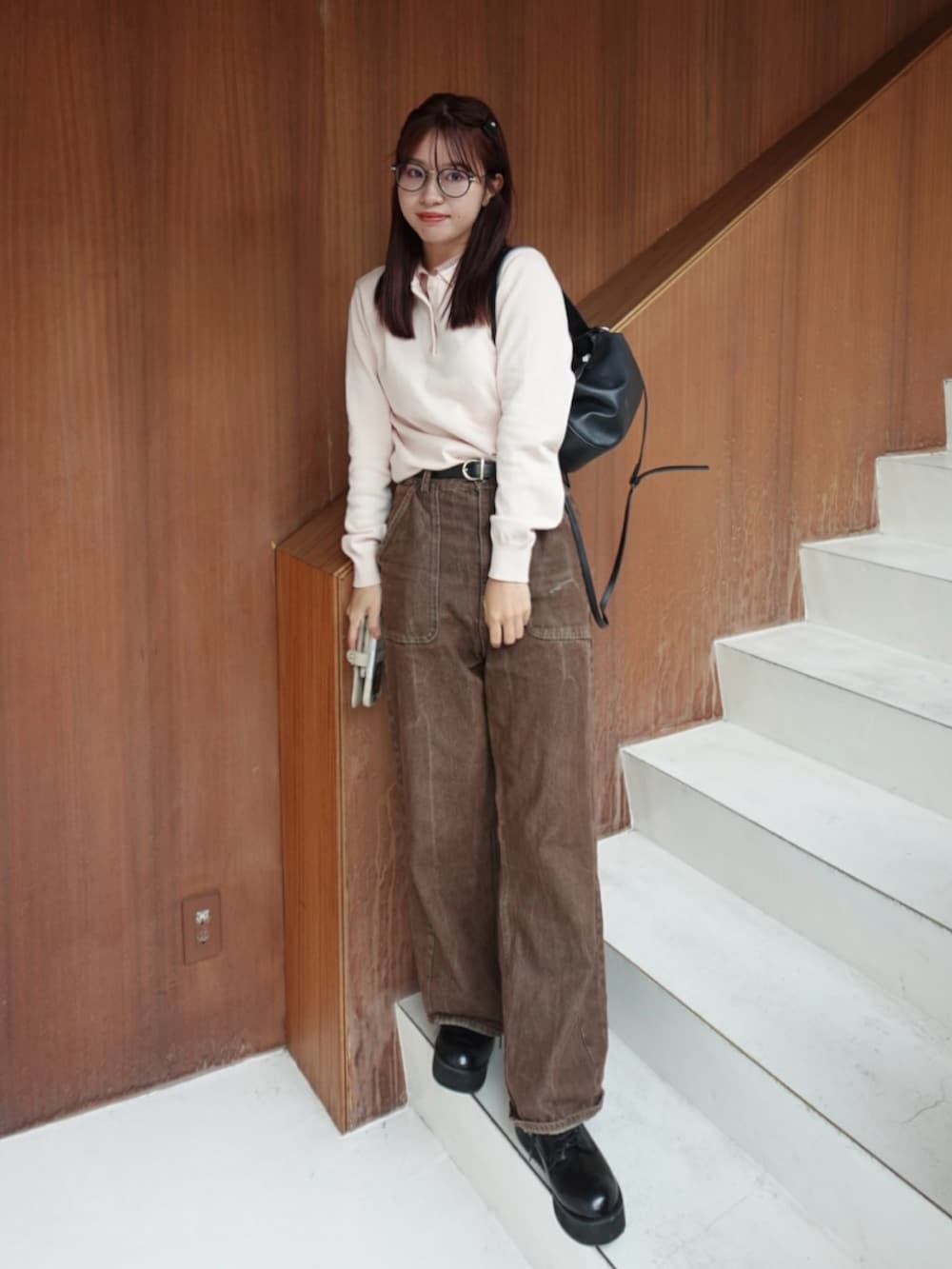 ブラック系のトートバッグ、ブラウン系のデニムパンツ、ブラック系のローファーを着用したレディースの秋コーディネートの4枚目の写真