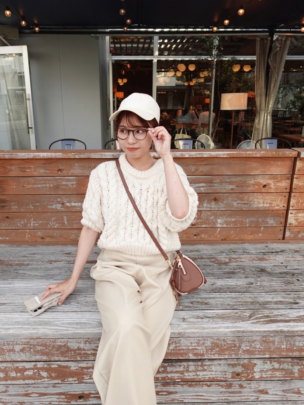 ベージュ系のサロペット/オーバーオール、ホワイト系のニット/セーター、グレー系のトートバッグを着用したレディースの夏コーディネートの4枚目の写真