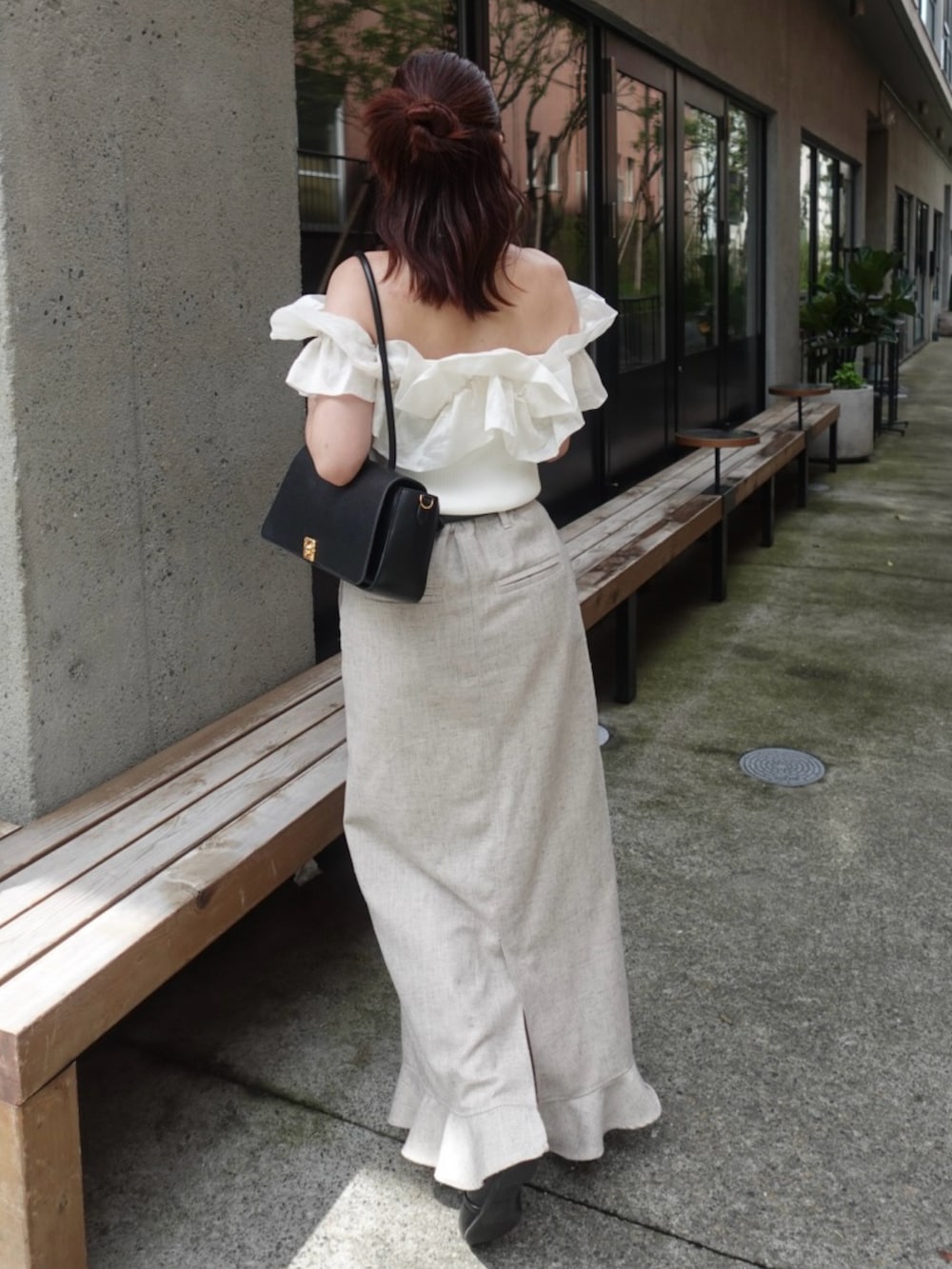 ベージュ系のスカート、ブラック系のパンプス、ホワイト系のニット/セーターを着用したレディースの夏コーディネートの2枚目の写真