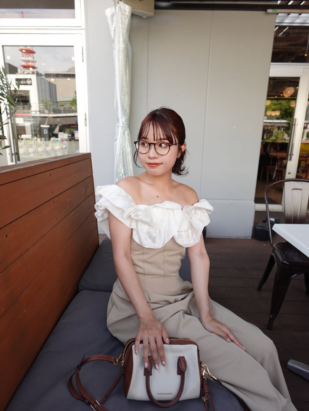 グレー系のトートバッグ、ブラウン系のパンプス、ホワイト系のニット/セーターを着用したレディースの夏コーディネートの4枚目の写真